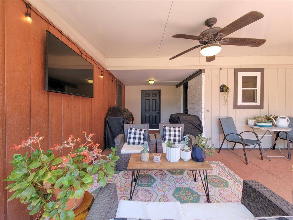 Covered patio with a ceiling fan, small dining set, perfect for outdoor relaxation and entertainment.