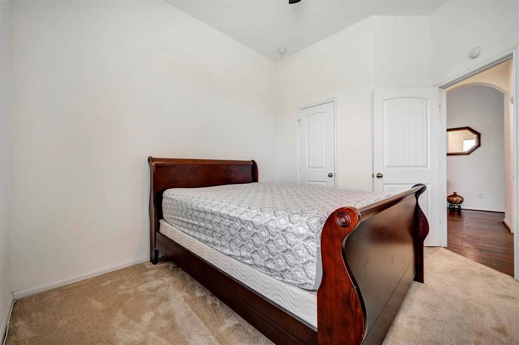 This spacious bedroom features ample natural lighting and plush carpeting, creating a comfortable and inviting living space.