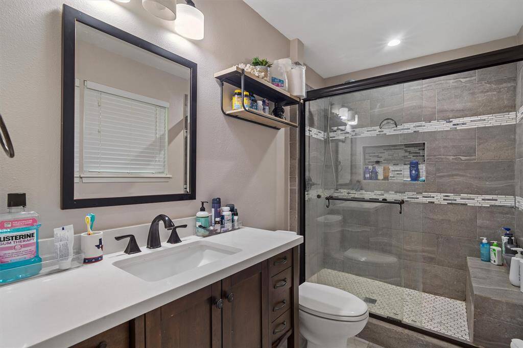 Primary en suite- modernized vanity with added counter space, framed mirror, stand alone fully tiled shower