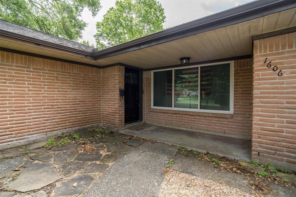 Covered front porch offering small seating area