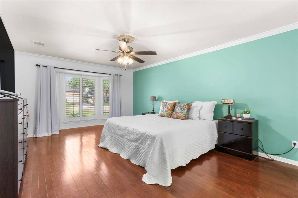 The light-and-bright primary bedroom is located on the first floor and boasts plantation shutters in te bay window. Room y enought for ing-sized furnishings and even a sitting area!