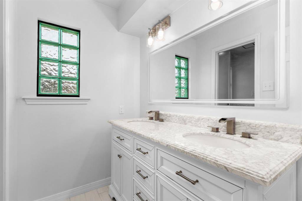 Even the upstairs secondary bath got the designer touch with upgraded double vessel vanity and stone countertops, hotel-style mirror with built-in lighting, and updated hardware, fixtures, and lighting.
