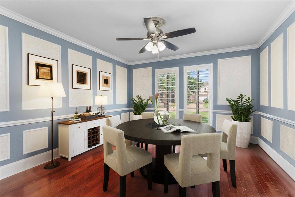 The dining room overlooks the front yard and boasts crown moulding and millwork for an elevated dining experience. This room, shown with a possible furniture arrangement, is currently being used as a work-from-home space for the current owners.