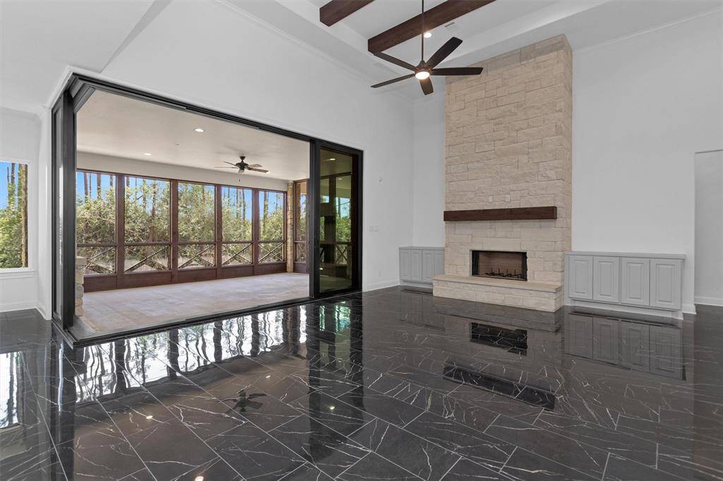Sliding glass door opens to a spacious screened-in patio, blending indoor luxury with the tranquility of forested surroundings.