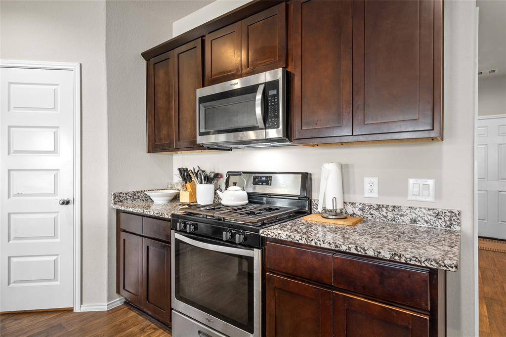 With its durable wood-look flooring and recessed lighting, this kitchen blends style and practicality. The walk-in pantry, generous counter space, and open sightlines to the rest of the home make it both beautiful and highly functional.