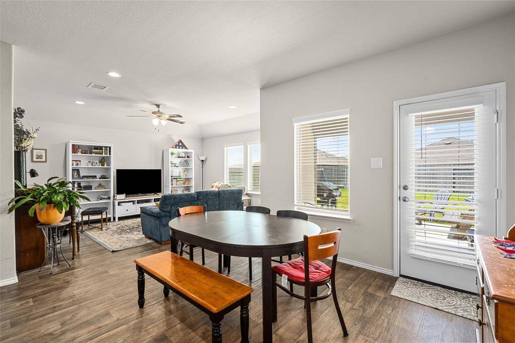 The kitchen flows effortlessly into the dining space and adjacent living area, creating an ideal layout for entertaining. Natural light pours in through the windows and patio door, enhancing the bright and welcoming atmosphere.