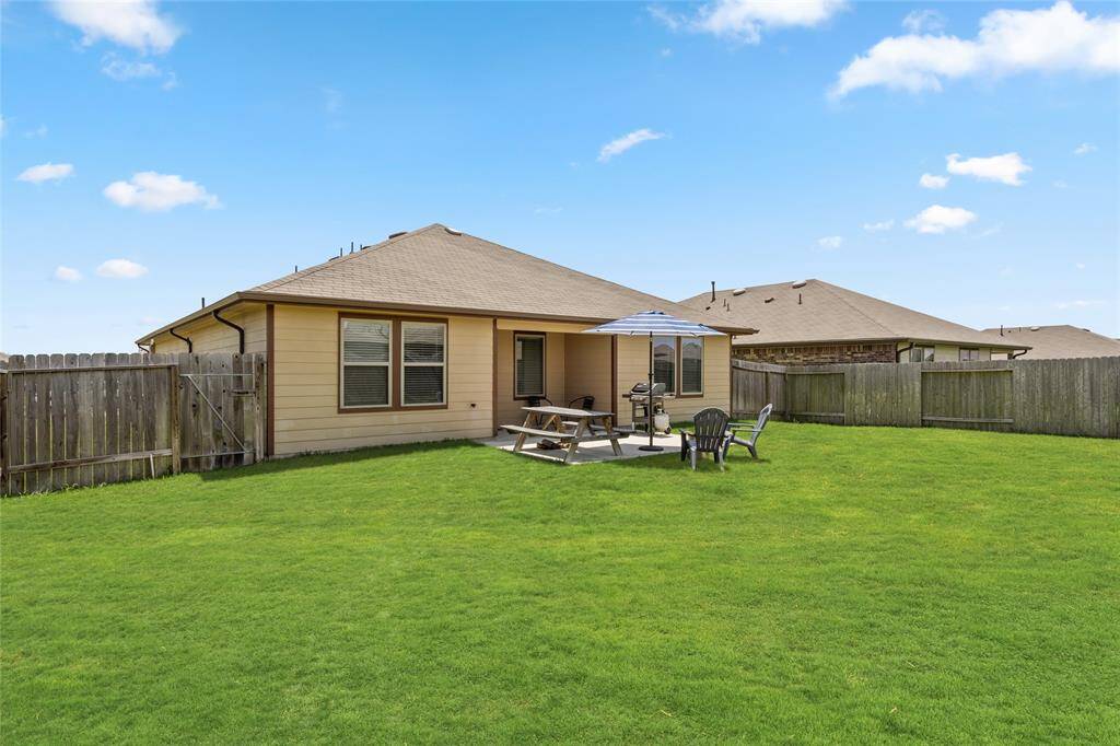 Enjoy the best of outdoor living in this oversized backyard, complete with a covered patio, grilling station, picnic area, and shaded seating under a large umbrella. The beautifully maintained, fully fenced lawn offers plenty of room for recreation, pets, or future landscaping dreams. Whether you’re hosting a summer cookout or enjoying a quiet evening under the stars, this versatile outdoor space is ready to accommodate every lifestyle.