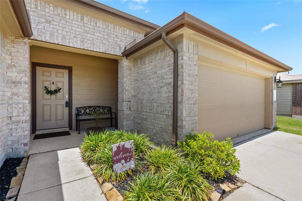 Covered front entry with sitting area offers a warm and inviting welcome. Accented by mature landscaping and a charming front door wreath, this entrance sets the tone for what’s inside.