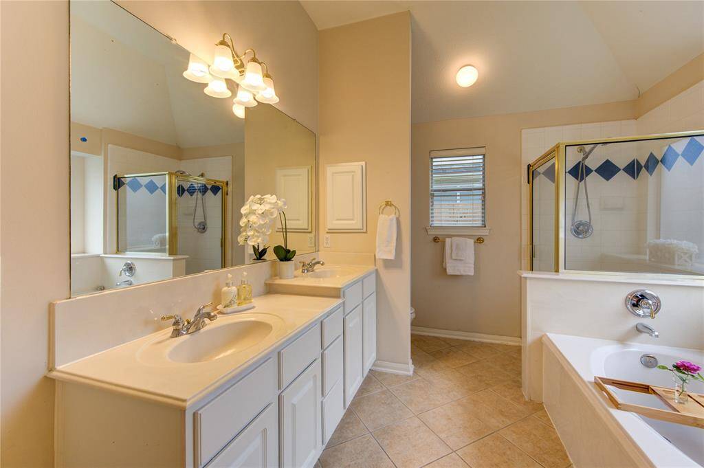 Spacious ensuite primary bath with a jetted tub, double vanity, and separate shower.