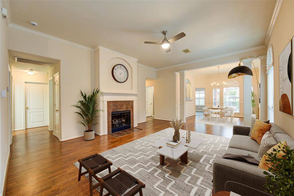 Virtually staged photo of living room to show how spacious it is and the easy flow into the dining room.