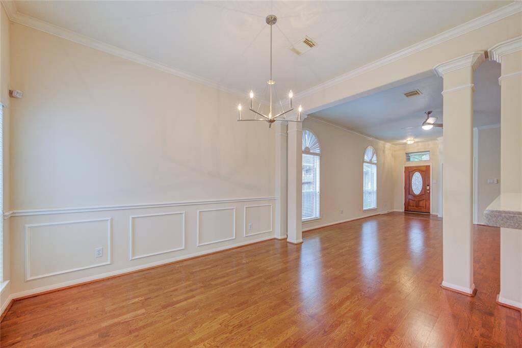 Dining room is bright and airy with a new, modern chandelier. The crown molding and chair railing add to the elegance of the room.