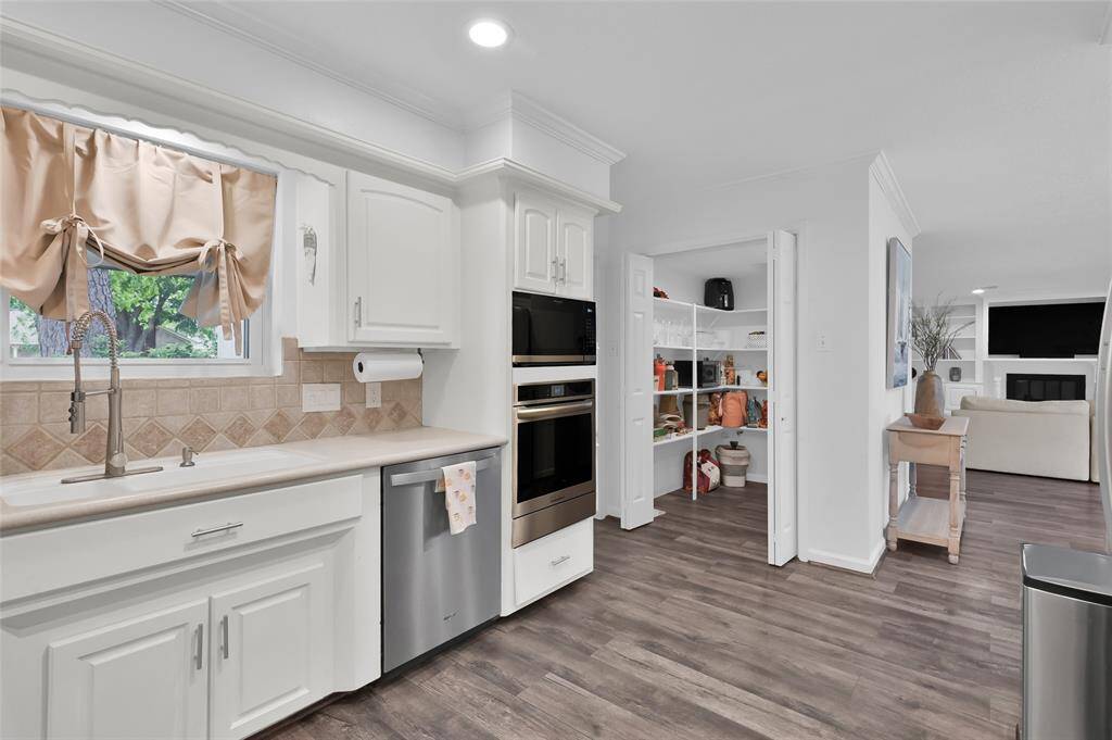 A stainless-steel faucet with pull-down sprayer helps make cleaning up a breeze while you look out the window to the Front Yard. The Whirlpool dishwasher makes doing dishes easy as well.