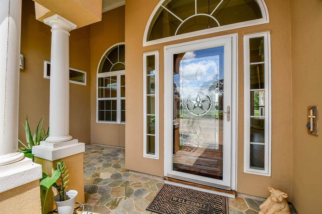 Beautiful grand entry with leaded mahogany wood front door and glass storm door