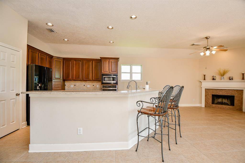 Large Chef's kitchen with beautiful wood cabinets and kitchen island overlooking the family room