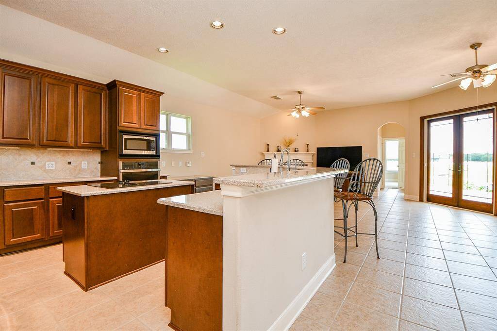 Electric cooktop island, and check out those beautiful double doors overlooking your backyard oasis.