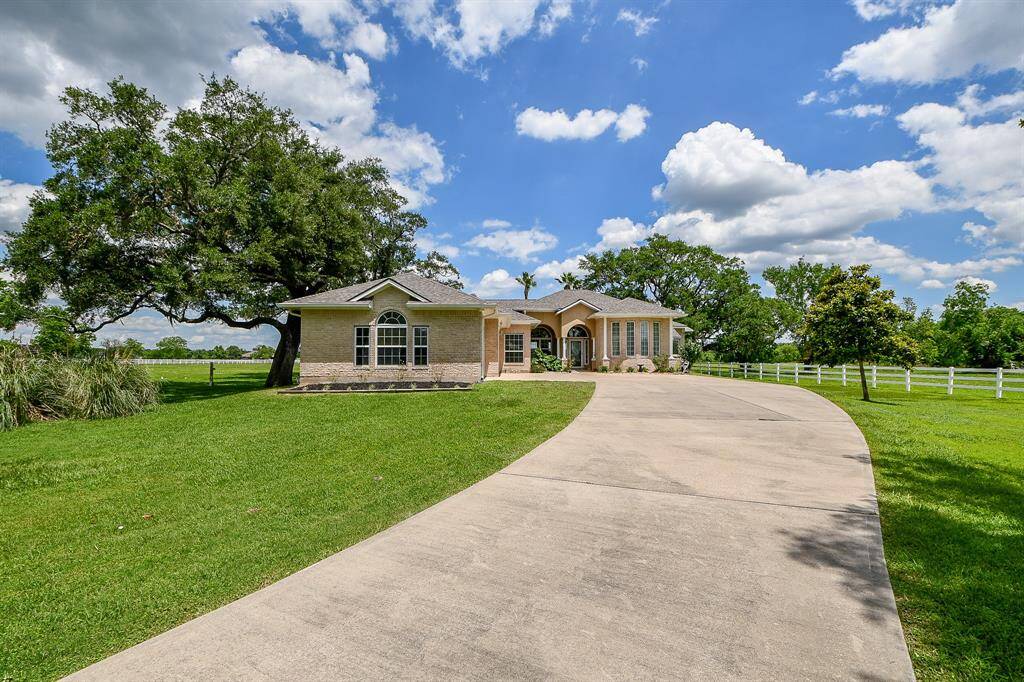 Front elevation of home surrounded by lush tress