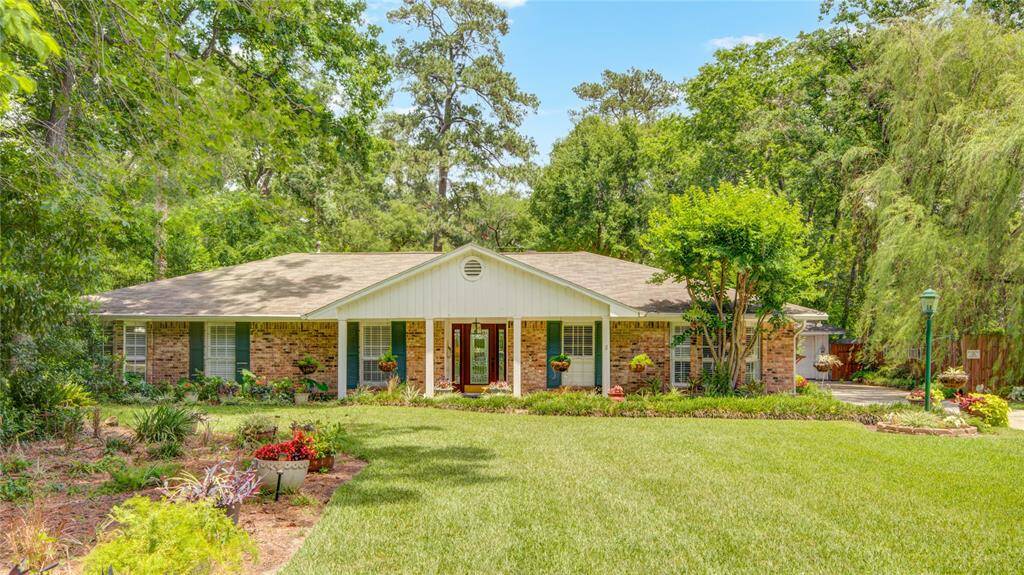 This charming ranch-style home is nestled on a spacious lot with lush landscaping and a welcoming front entry.