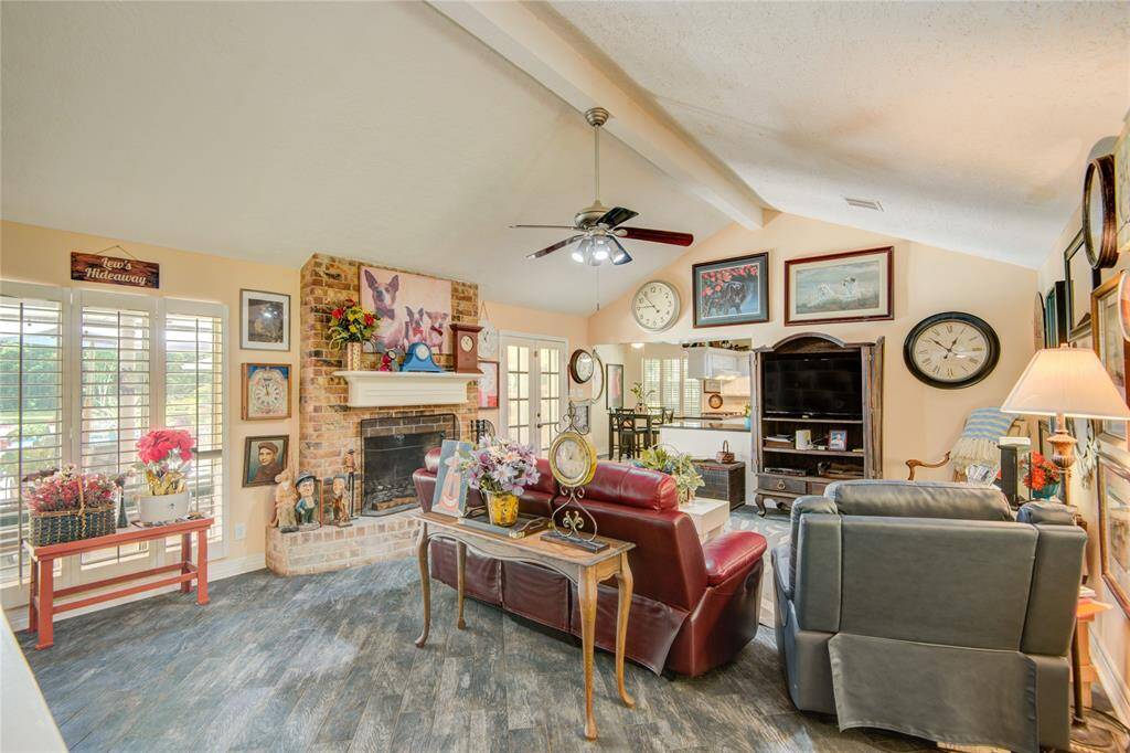 From this wider perspective of the family room, you can see the windows to the left of the fireplace, along with the French doors leading to the patio—filling the space with natural light and backyard views.