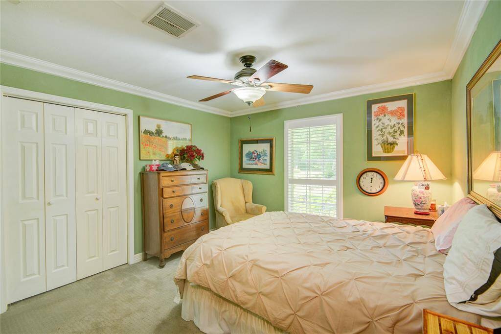 The second secondary bedroom features peaceful front yard views and a soothing pale sage color palette, creating a calm and restful retreat.