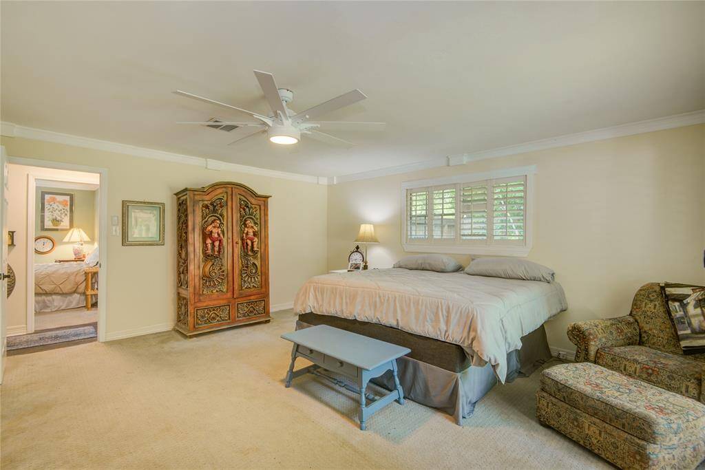 An alternate view of the primary bedroom looks out toward the hallway, offering a glimpse of a secondary bedroom just across the way.