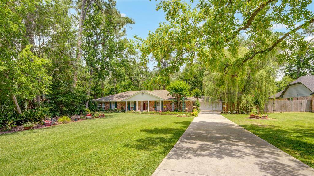 The front elevation reveals the home’s deep setback from the street, offering added privacy and a long driveway with ample parking for guests or family.