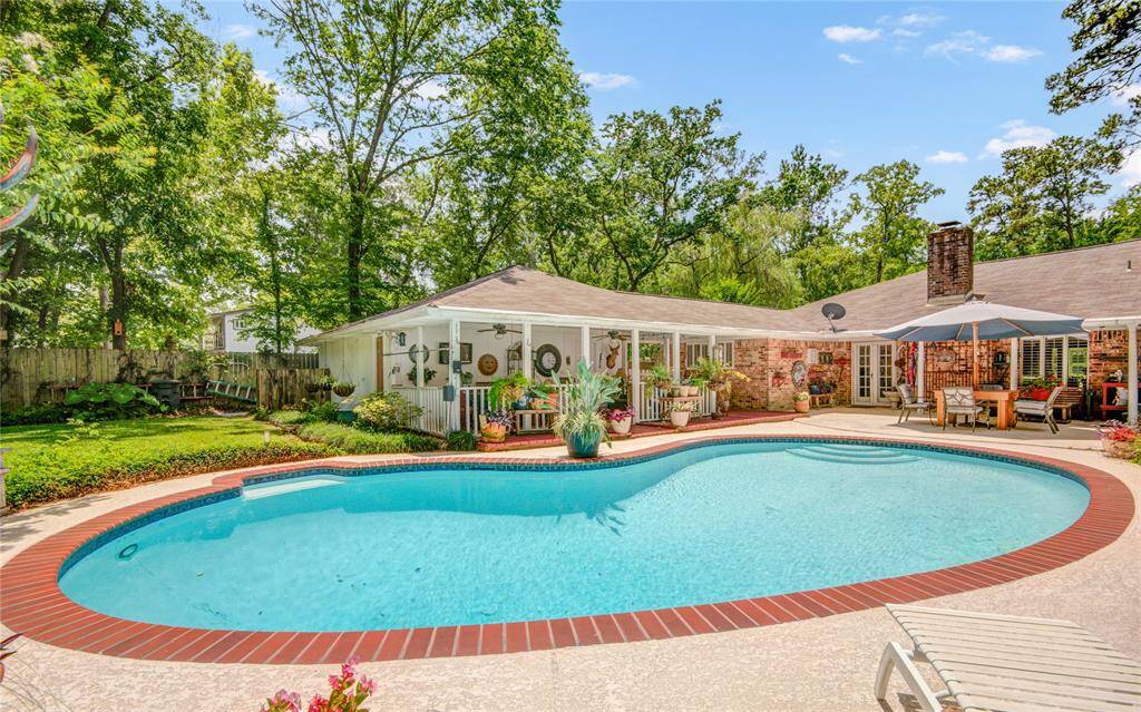 A close-up of the pool highlights the inviting water with the spacious covered patio just beyond, ideal for relaxing and entertaining outdoors.