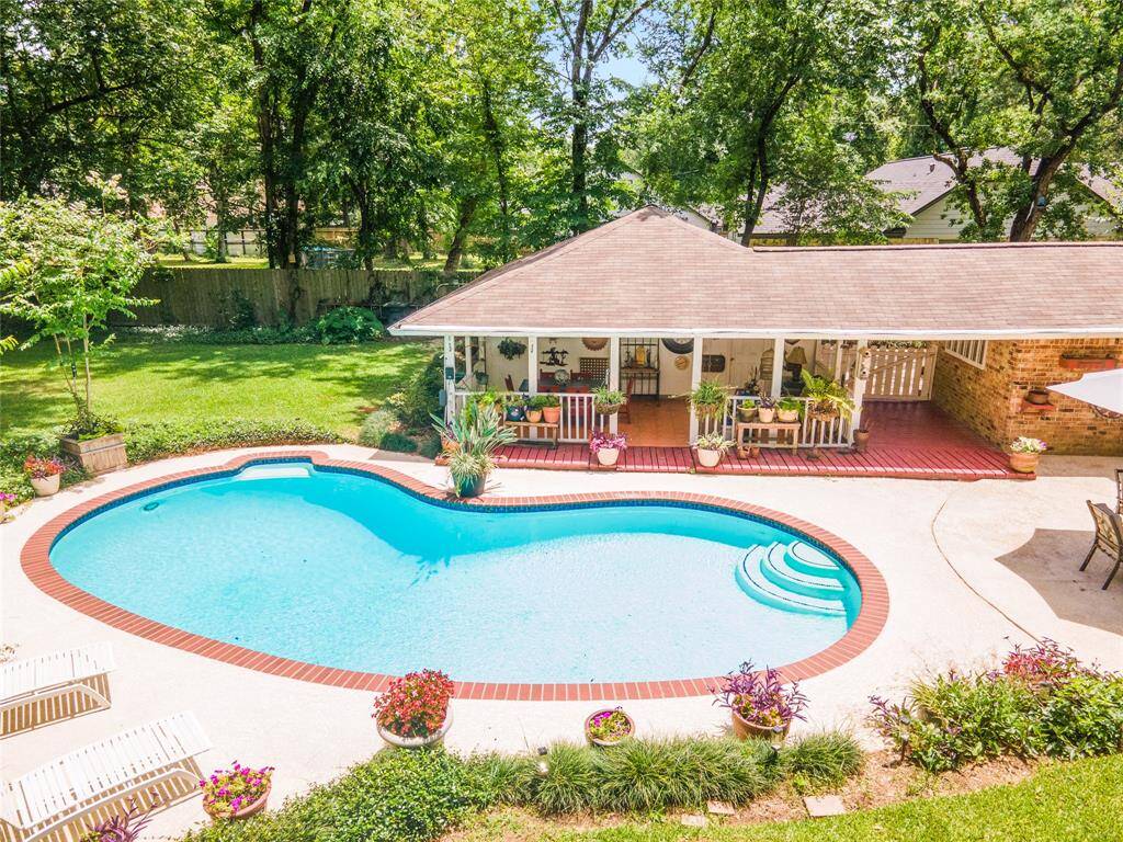 This aerial view showcases the sparkling pool alongside the spacious covered patio, highlighting the perfect blend of relaxation and outdoor entertaining space.
