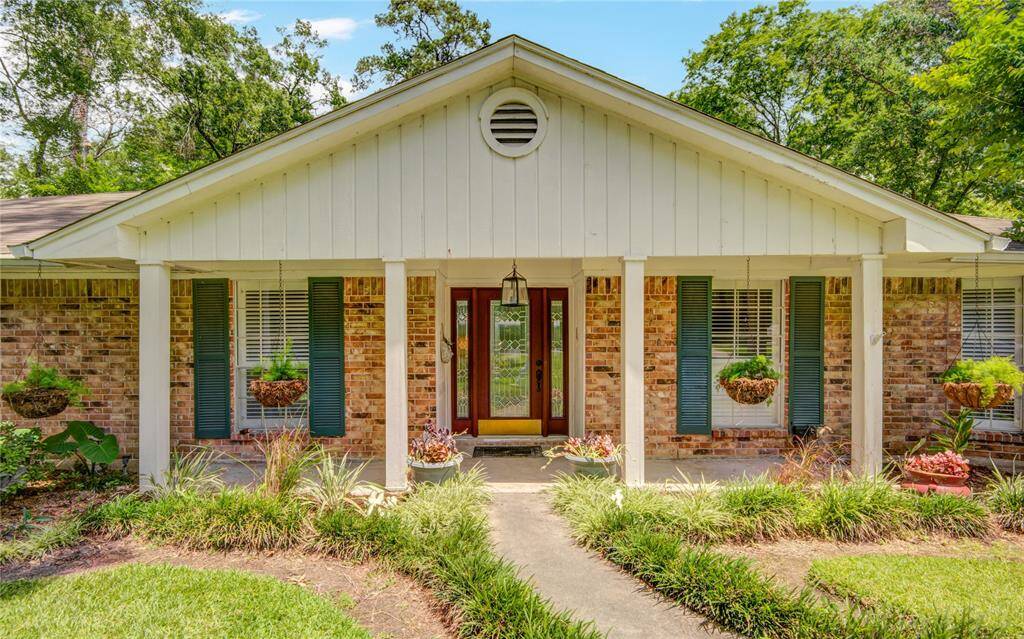 A closer look at the inviting front porch showcases charming brickwork, vibrant shutters, and beautifully maintained landscaping.