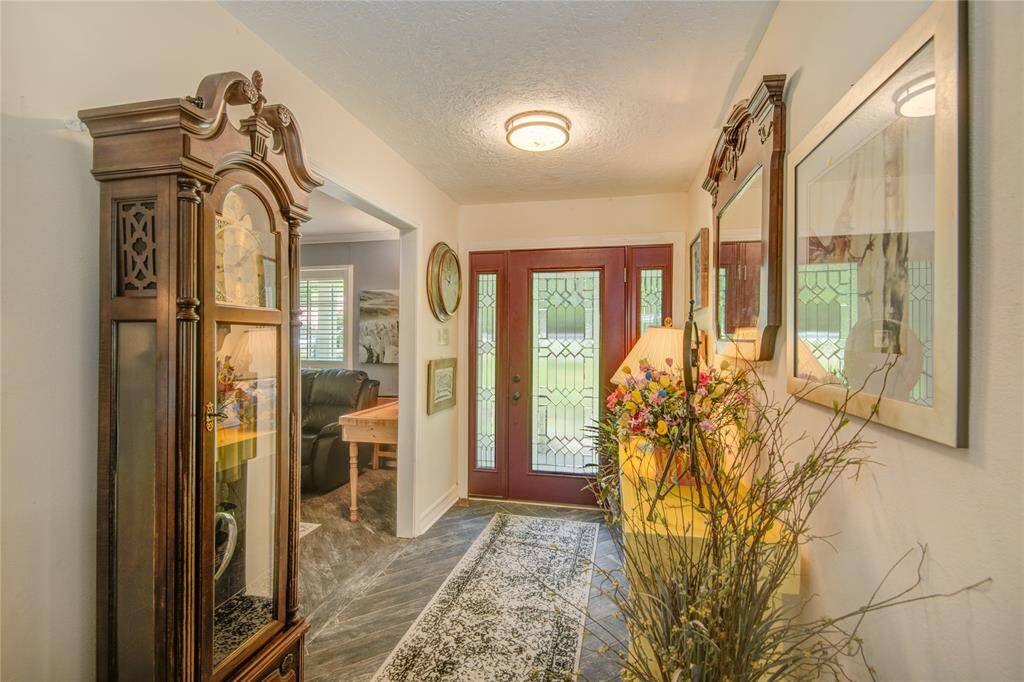 The foyer features a stunning leaded glass front door with sidelight panels and opens seamlessly to the spacious living room on the left.