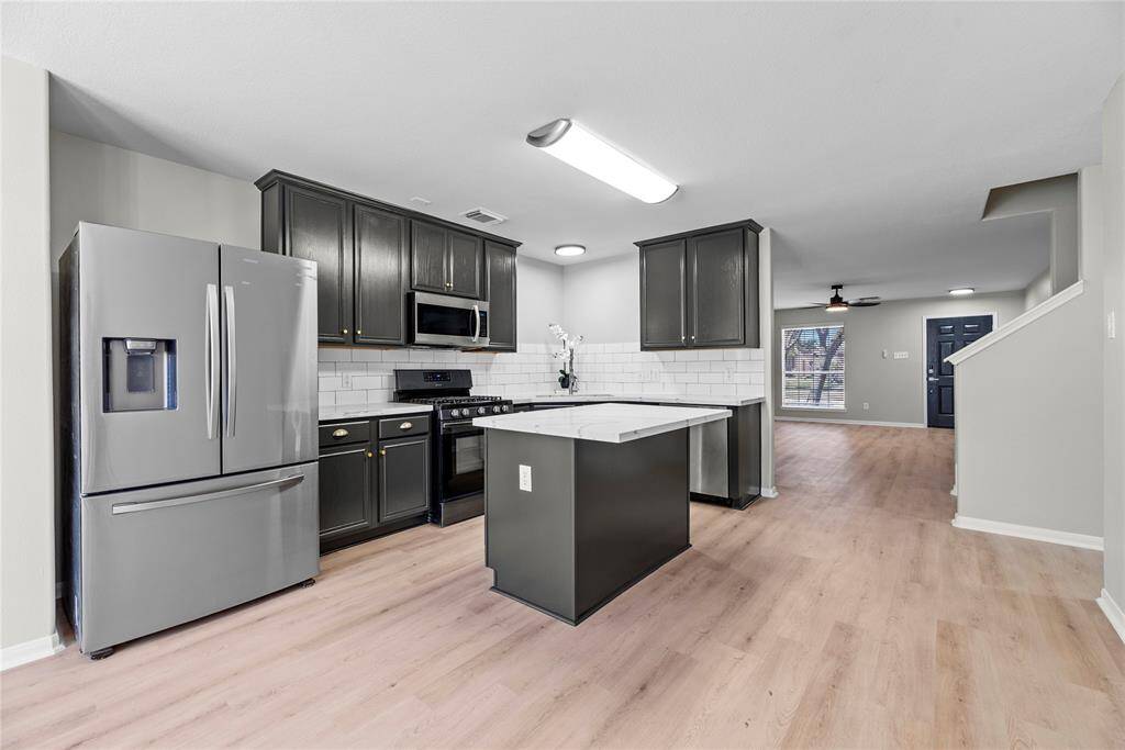 Kitchen, with freshly painted cabinets, large under mount sink and gas stove. Stainless steel appliances.