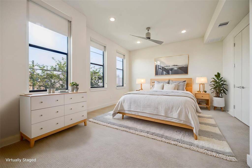 This spacious primary bedroom has recessed lights & a modern ceiling fan.