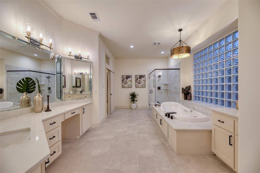 Remodeled bathroom features neutral tile, updated fixtures, and generous counter space create a clean and relaxing spa atmosphere.