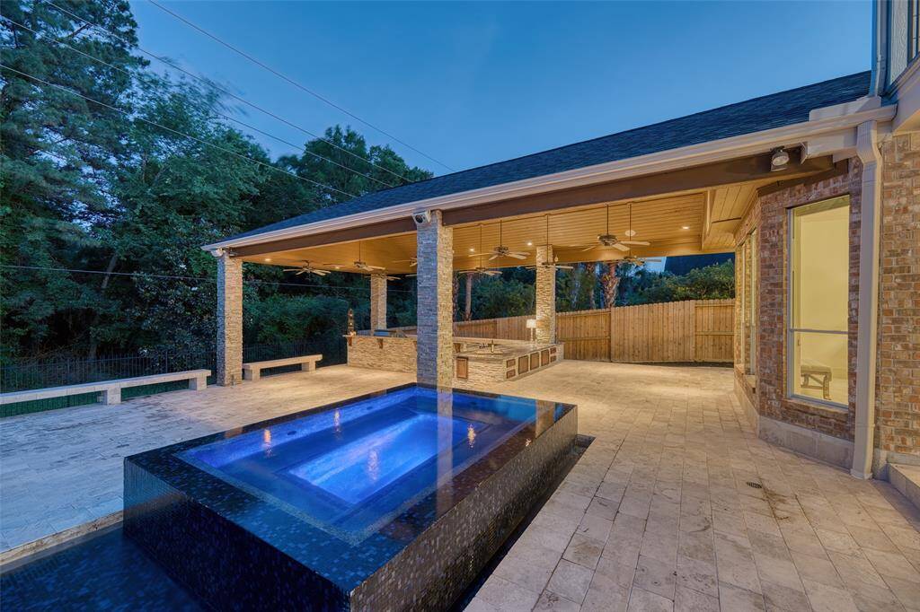 Enjoy year-round comfort in the heated spa connected to the pool with tranquil water features.