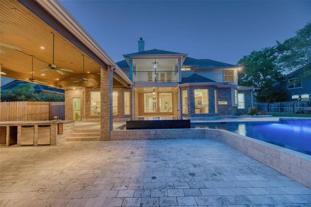 Dusk photo of pool and hot tub glowing under ambient lighting for resort-style evenings.