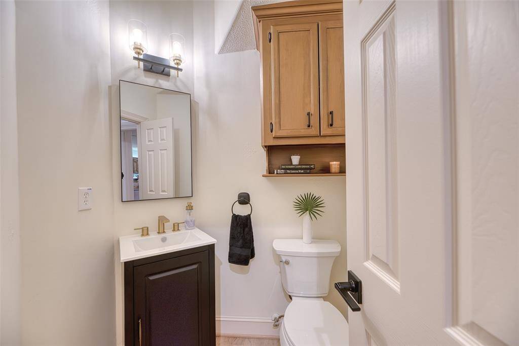This powder room features updated fixtures, a pedestal sink, and neutral tones—perfect for guests.