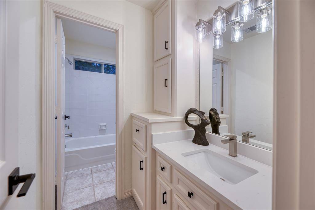 All secondary baths feature clean tile work, modern lighting, and plenty of cabinet storage.