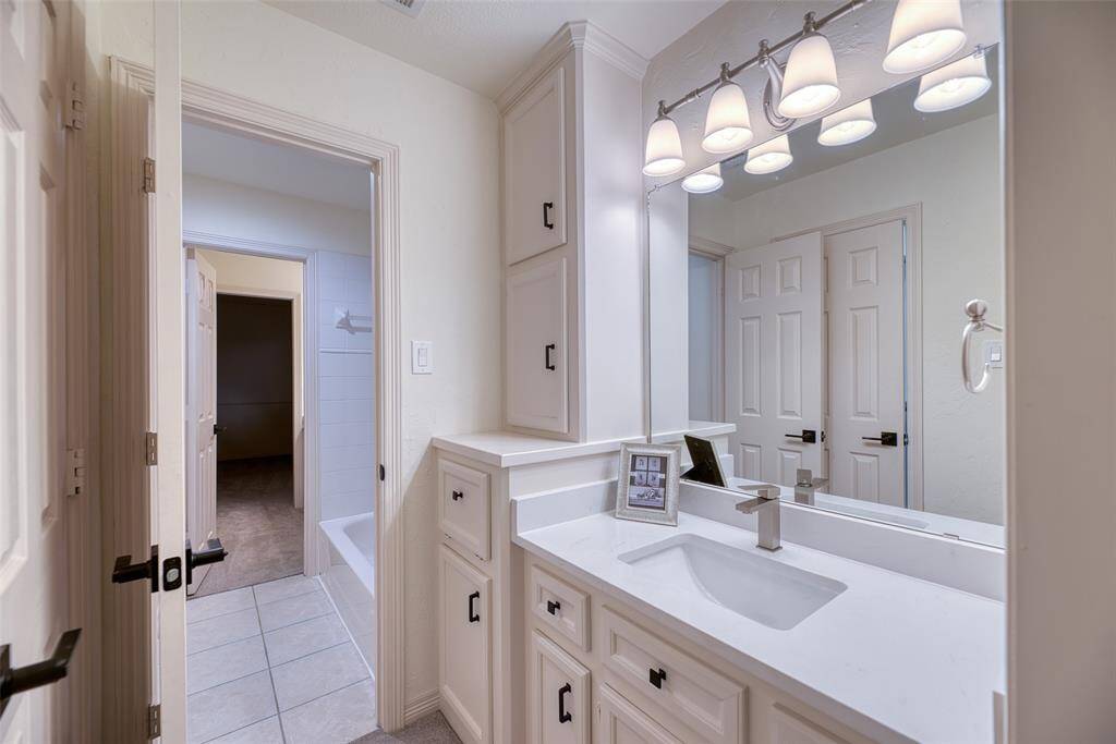 All secondary baths feature clean tile work, modern lighting, and plenty of cabinet storage.