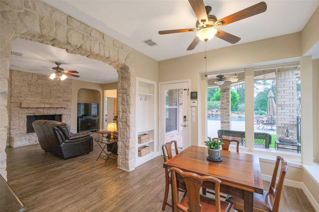 Bright breakfast room with large windows offering scenic views, open to the family room for an inviting, open feel.