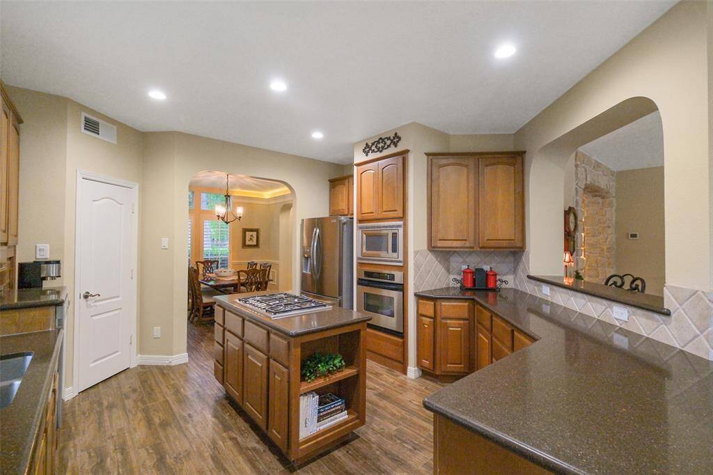 This kitchen offers sleek stainless steel appliances, convenient pull-out shelving and a spacious walk-in pantry.