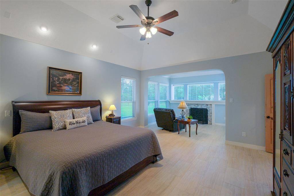 1st floor primary bedroom featuring a cozy sitting area with a fireplace with an updated stone surround.