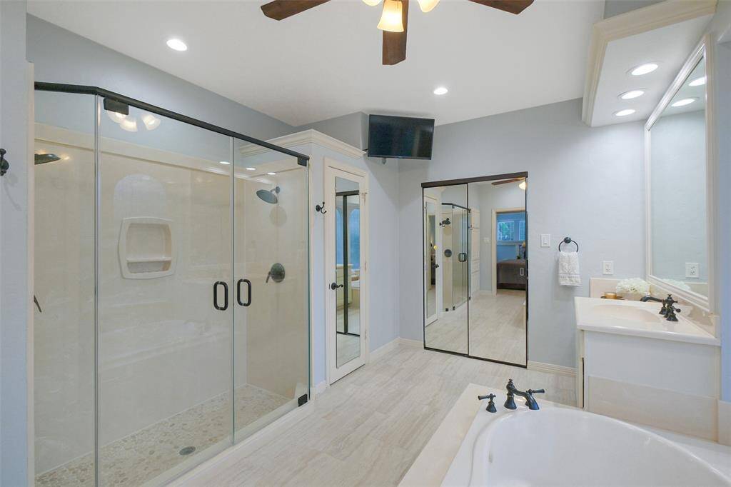 A modernized dual-head shower with updated tile and doors offering a spacious and invigorating experience.