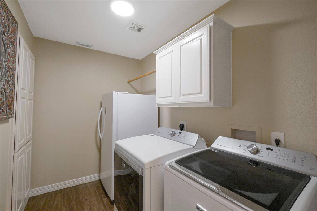 Convenient first-floor laundry room with built-in storage and space for an extra refrigerator. LED lighting recently installed.