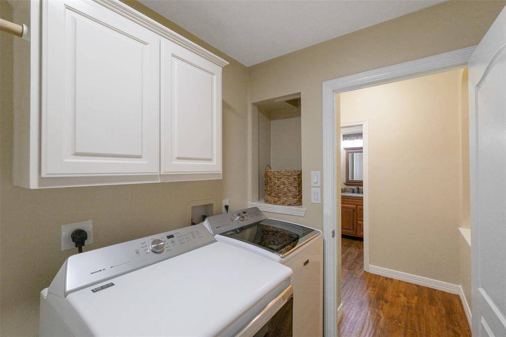 Functional laundry room with ample cabinetry for storage and a convenient laundry chute from upstairs.