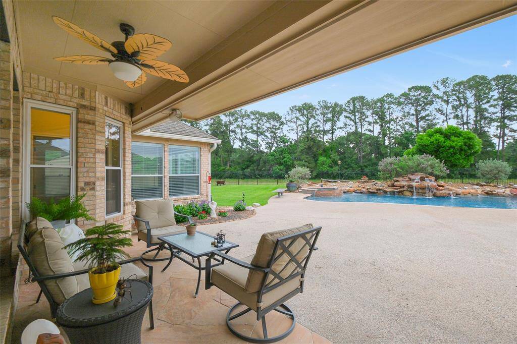 Enjoy tranquil views from the inviting covered patio. Features outdoor speakers and a ceiling fan.