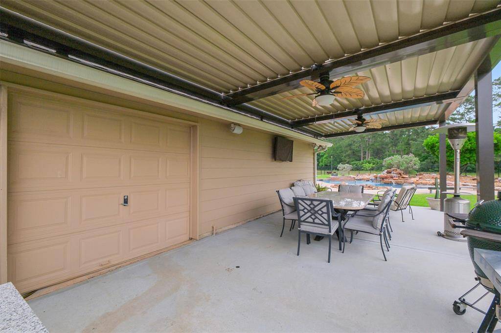 You can access the inviting covered patio from the garage, featuring a motorized pergola, ceiling fans, and built-in speakers for ultimate comfort and entertainment.