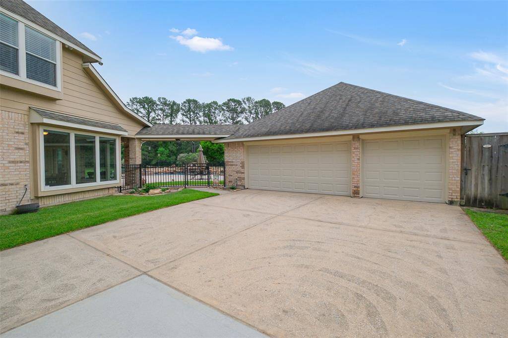 Expansive 3-car garage with an extended workspace, featuring sheetrock walls, cabinets, enhanced lighting, attic decking and extra 30-amp and 50-amp breaker for RV.