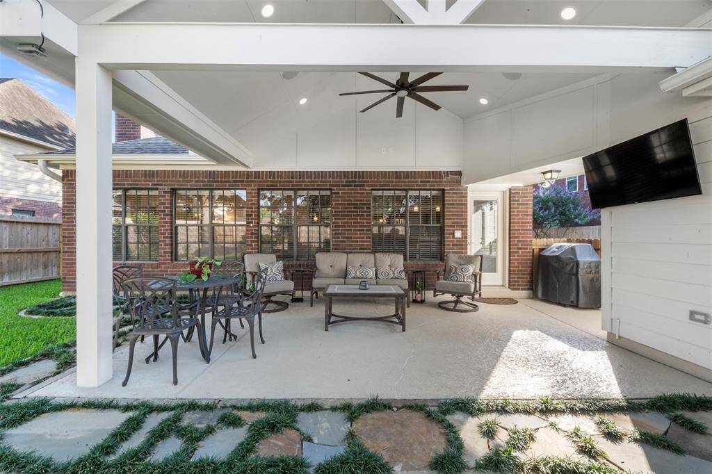 The porch has recessed lighting, a fan, and beautiful flagstone.