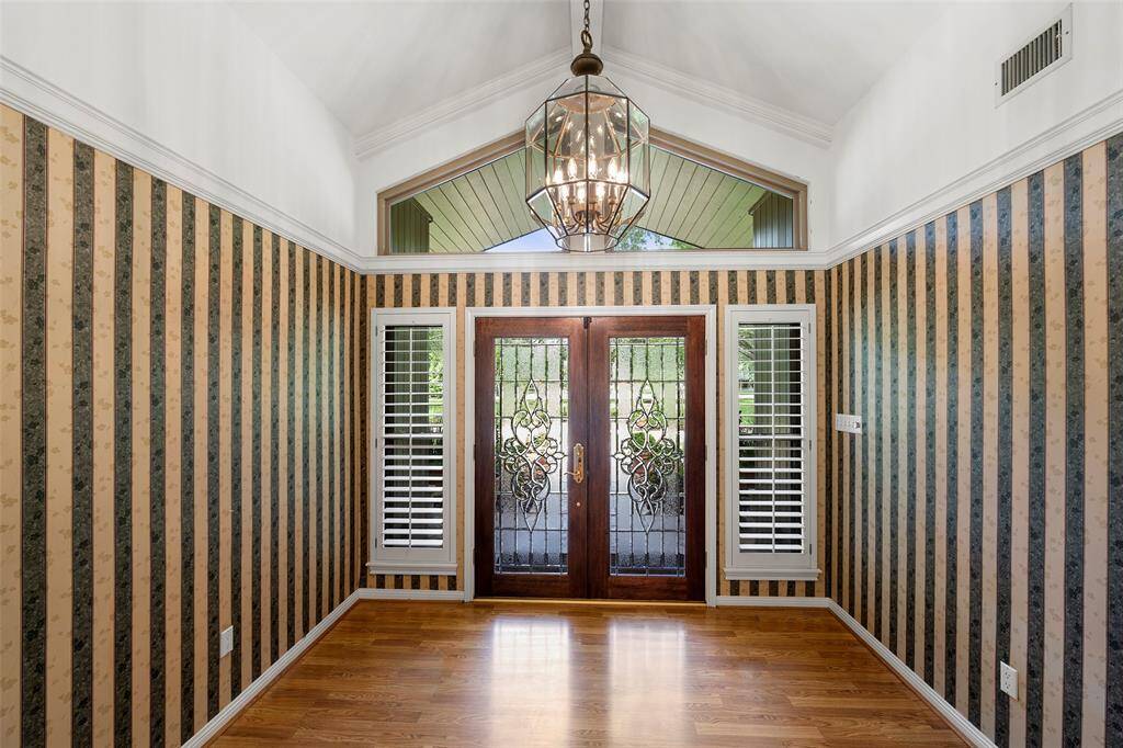 Open the double leaded glass doors to a gorgeous hallway with tons of natural light, pretty chandelier, crown molding & more.