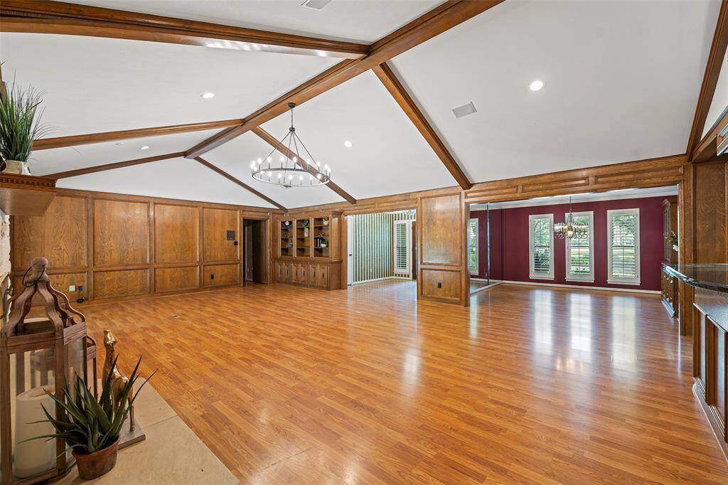 Adjacent to the main living space, the formal dining area features bold accent walls, floor-to-ceiling windows with plantation shutters, and a mirrored wall that adds depth and natural light. Perfect for entertaining or relaxed family living.