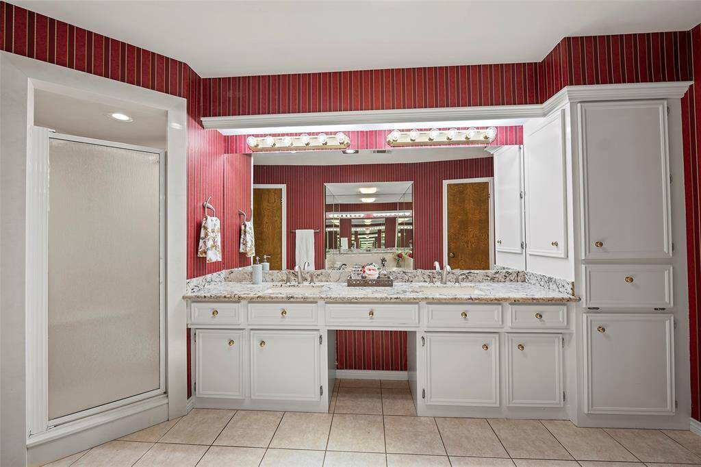 A primary en-suite with crisp white cabinets, granite countertops and dual sink vanity has plenty of storage, along with a vanity cabinet with laundry storage too!